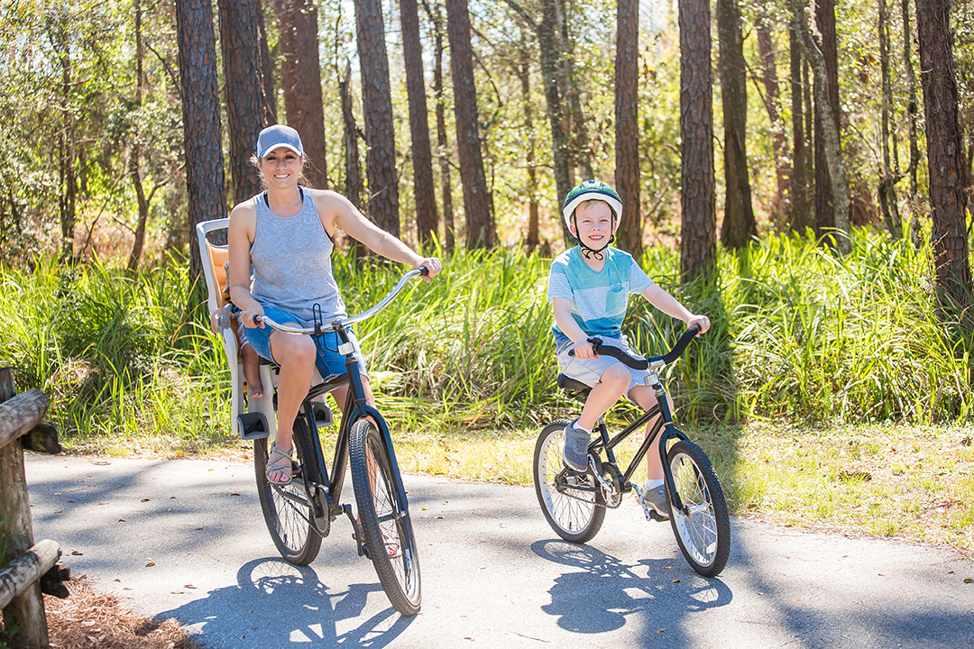 Mother and child riding bikes on a nature trail in St. Petersburg FL during a screen-free summer activity